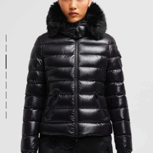 Moncler jacka badyf hooded short down  jacket  - Säljer min moncler vinterjacka i strl 0. Jackan är i väldigt bra skick. Jackan har även äkta päls då den köptes INNAN moncler slutade sälja äkta päls.