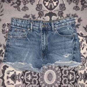 Blå jeansshorts - Snygga blå jeansshorts från Gina Tricot med slitna detaljer och fransig kant. Perfekta för en avslappnad stil. 💕💕