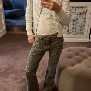 Grå leopardmönstrade byxor - Snygga grå byxor med leopardmönster. De har en bootcut-stil och är lågmidjade, vilket ger en trendig look. Perfekta för att sticka ut med ett djärvt mönster.