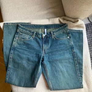 Blå jeans från Weekday - Snygga blå jeans från Weekday med klassisk femficksdesign och knappgylf. Perfekta för en avslappnad stil. Märket 'ARROW' syns på insidan. Passar bra till både sneakers och boots. De är knappt använda så inget slitage så förutom på ena bakbenet för det är lite noppriga 💕 skriv för frågor!!