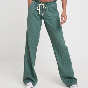 Gröna linnebyxor från Roxy  - Snygga gröna linnebyxor med en avslappnad passform och snörning i midjan. Perfekta för en bekväm och stilren look. Byxorna är dock lite uppklippta av skräddare och passar mig perfekt som är 165 men även dig som är snäppet längre.