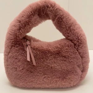 Rosa fluffig väska från Gina Tricot - Säljer en supermjuk och fluffig rosa väska från Gina Tricot. Helt ny, aldrig använd. Den har en praktisk dragkedja upptill och är perfekt för att ge din outfit en mysig touch. Väskan är tillverkad i syntetmaterial och har en unik design som verkligen sticker ut. Kontakta innan köp.