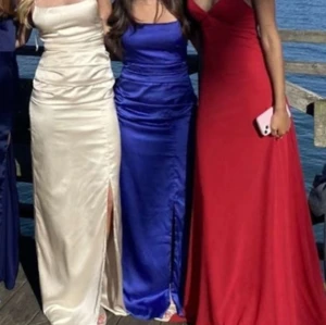 Blå balklänning med öppen rygg - Säljer nu min så fina balklänning som bara har använts vid ett tillfälle. Klänningen har en slits framtill och korsade band i ryggen. Den är uppsydd så den passar lite kortare personer.