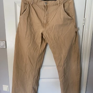 Beige cargobyxor från 157 - Beige-bruna ”arbetsbyxor” från Lager 157. Sitter som M/L med baggy fit. bra skick! Tveka inte att höra av dig om du har frågor eller vill ha fler bilder!