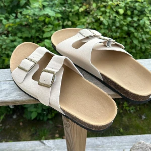 Beige sandaler med spännen - Säljer ett par snygga och bekväma beige sandaler med dubbla spännen. Perfekta för sommaren! De har en ergonomisk fotbädd och är i storlek herr 43. Aldrig använda. 
