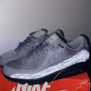 Grå Nike Air Max sneakers - Säljer ett par grå Nike Air Max sneakers  har gått ut med dom en gång so typ helt nya . Skorna har en snygg design med en reflekterande detalj på sidan och är perfekta för både vardag och träning. De har en bekväm passform med snörning och en dämpande sula. det är storlek 45 och en halv men passar bra också i 44 och 45 