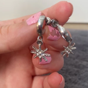 Örhängen  - Ett par örhängen med med en liten hängande sol. Örhängena är aldrig använda och har båda pluttarna kvar. Säljer då dom inte används 