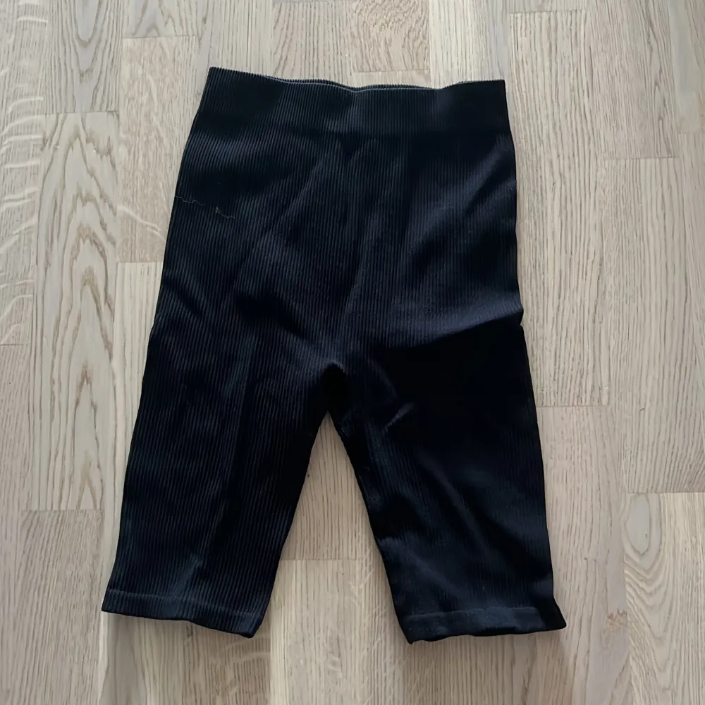 Säljer ett par svarta ribbade shorts. De är superbekväma och perfekta för både vardag och träning. De har en tight passform och är gjorda av ett stretchigt material som formar sig efter kroppen. Perfekta för sommaren! 🖤. Shorts.