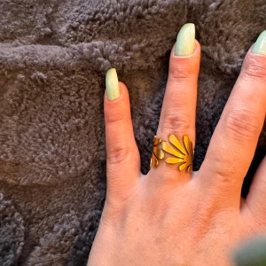 Guldfärgad ring med bladmotiv - Säljer en superfin guldfärgad ring (S.Steel)med ett unikt bladmotiv. Ringen är justerbar och passar de flesta storlekar. Perfekt för att ge din outfit en extra touch av elegans! 🌿✨