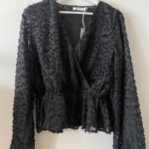 Omlott blus - Svart omlott blus från na-kd. Helt oanvänd med prislapp kvar.