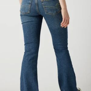 Bootcut jeans från Junkyard - Populär modell från Junkyard med låg midja och lätt utställda nedtill. Snygg blå tvätt. Fint skick! 