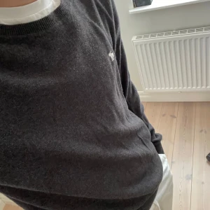 Stickad tröja - Stickad tröja från abercombie and fitch. Stilren tröja perfekt för sommarkvällar eller höstdagar. En tråd som hänger vid ena mudden annars inga tecken på användning. Pris kan diskuteras 