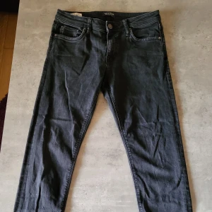 Svarta jeans från Jack & Jones - Säljer ett par svarta jeans från Jack & Jones. De är i bra skick och har en klassisk femficksdesign med dragkedja och knapp. Perfekta för både vardag och fest!
