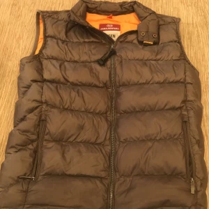 Parajumper väst (sällsynt) - Strl Y-M bra skick förutom att det är ett litet hål i ryggen och att jag fick en atugraf av en fotbollspelare på insidan av västen men sen är det inget märkvärdigt färg- oliv grön blandat med guld