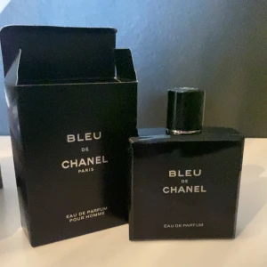 Bleu de Chanel EDP - Säljer en elegant Bleu de Chanel EDP 100 ml. Flaskan är stilrent designad i svart med en enkel och modern look. Perfekt för den som vill ha en sofistikerad doft som passar både till vardags och fest. Kommer i originalförpackni