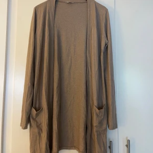 Kofta  - En beige kofta i mycket skönt och mjukt material, fin kvalite. I mycket gott skick 