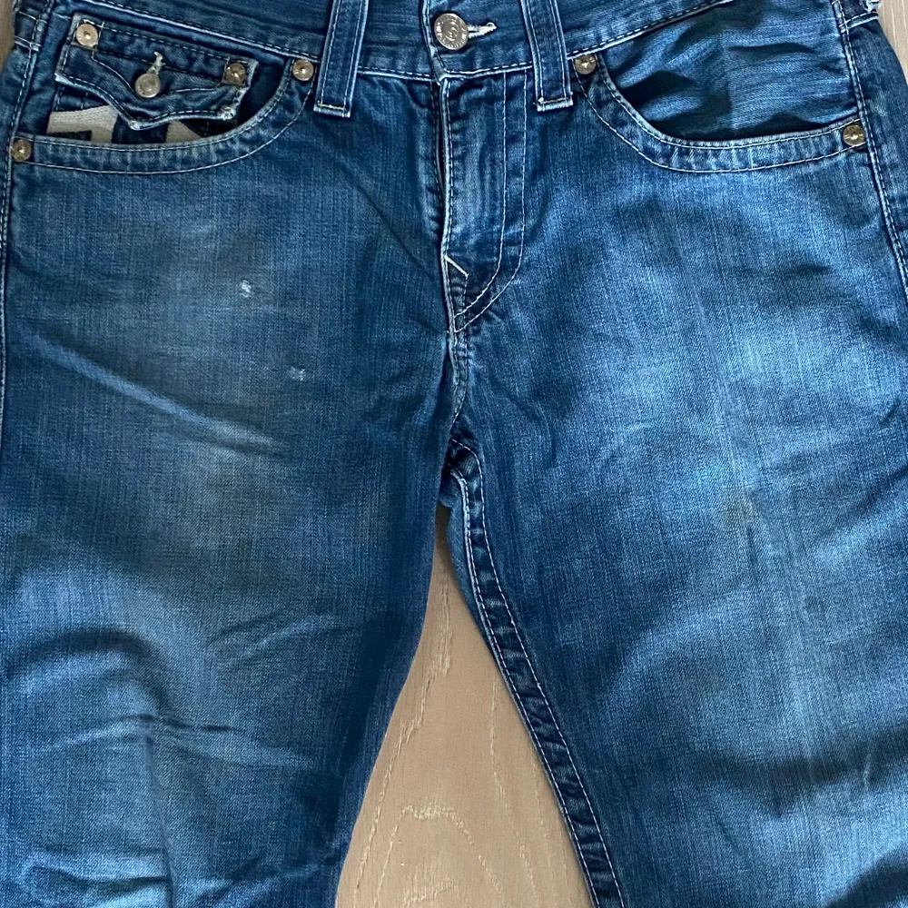 Snygga true religion i bootcut fit i jätte bra skick. De är lite missfärgade i fram på låren som syns på bilden. Säljer eftersom att de är för korta för mig. Hör av er ifall ni vill ha måtten!. Jeans & Byxor.