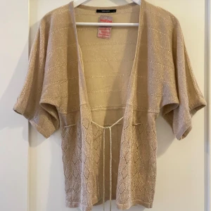 Guldglittrig kofta - En söt liten kofta som glittrar. Storlek L men skulle säga att den passar de flesta storlekar då den går att knyta i midjan. 