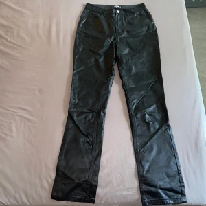 Svarta byxor i skinnimitation - Säljer ett par svarta byxor i skinnimitation från Missguided Tall i storlek 36. De har en snygg straight passform. Endast testade. 