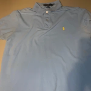 Ljusblå polo T-shirt  - En väldigt fin polo tröja som är i bra kvalité. Skicka förslag.