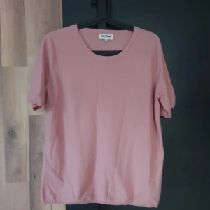 Rosa kashmirtröja från Soft Goat - Säljer en supermjuk och lyxig rosa tröja från Soft Goat, gjord av 100% kashmir. Tröjan har en enkel och stilren design med korta ärmar och rund hals. Perfekt för både vardag och lite finare tillfällen. Passar perfekt till höst och vår!