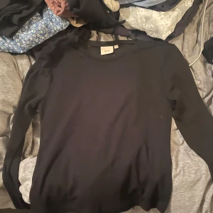 spets svart  - en fin ”spets” tröja som sitter väldigt mjukt o fint på kroppen, använd 2 gånger. Rätt så genomskinlig, ifrån Nelly 