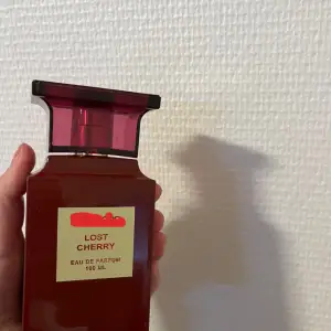 Säljer en flaska Lost Cherry Eau de Parfum, 100 ml. Flaskan är elegant och djup röd med en fyrkantig form och ett matchande rött lock. Doften är lyxig och perfekt för den som älskar en söt och fruktig parfym. Perfekt för både vardag och speciella ti