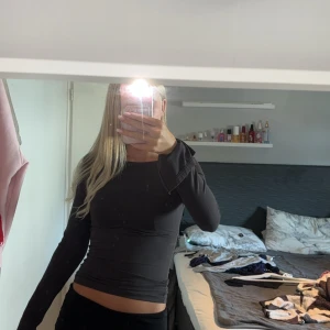 Mörk grå långärmad topp - Säljer en mörkgrå långärmad topp som är tight och perfekt för höst och vinter. Den har en enkel och stilren design som passar till det mesta. Toppen är i bra skick och redo för nya äventyr!