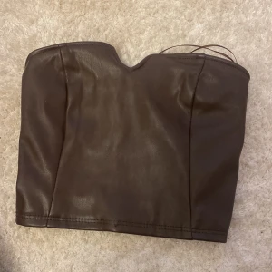 Topp - Brun topp i läderimitation. Endast testad men har spruckit lite i sömnen från när jag testade den. Storlek XS. Vid fler frågor/bilder skriv! Tar emot prisförslag❤️