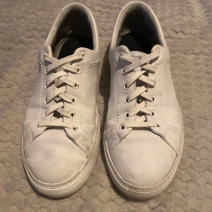 Vita sneakers från Jacob Cohen - Snygga vita sneakers från Jacob Cohen med klassisk snörning. Tillverkade i Italien, dessa skor har en stilren design med märkets logga på hälen. Perfekta för en avslappnad look.