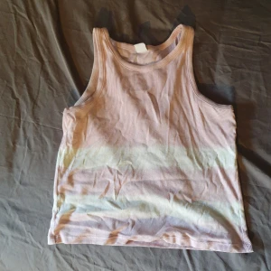 Ribbad ärmlös topp från Lindex - Säljer en ribbad ärmlös topp från Lindex i ljusrosa och vit. Perfekt för med ett par slitna jeans för en y2k stil💘