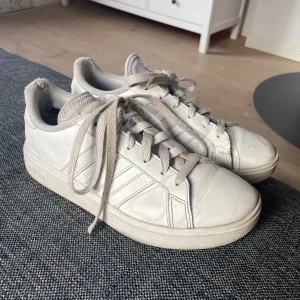 Adidas sneakers - Säljer ett par vita sneakers från Adidas med snörning. Skorna har en bekväm sula och är perfekta för vardagsbruk. De är i en stilren design som passar till det mesta. De har tecken på användning och slitage, se bild 5. De passar storlekar från 36-39 men är i storlek 37/38🤗💕