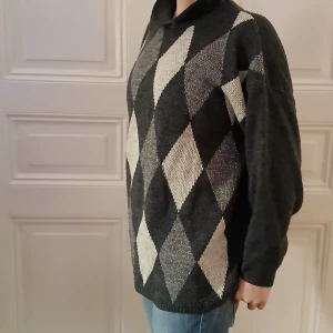 Grå tröja med diamantmönster - Säljer en stilren grå tröja med ett klassiskt diamantmönster i ljusare nyanser. Tröjan har långa ärmar och en bekväm passform, perfekt för kyligare dagar. Den är tillverkad i ett mjukt material som ger en skön känsla mot huden.