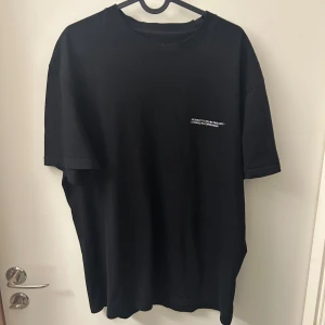 Svart t-shirt från Orginals studio - Snygg svart t-shirt från Originals Studio med tryck på både fram- och baksidan. Perfekt för en avslappnad stil.