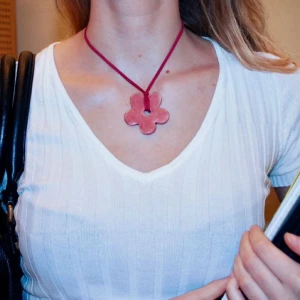 Rosa blomformat halsband - Charmigt halsband med en stor rosa blomma som hänge. Handgjort i keramik av oss - Vivid UF. Om annan färg önskas på band, tar vi emot beställningar i Instagram DM. @_vividuf