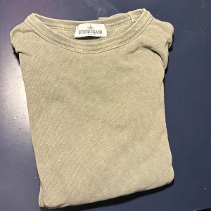 Grön tröja från Stone Island Junior - Säljer en stilren grön tröja från Stone Island Junior. Inte det bästa skicket. Perfekt för en avslappnad och trendig look.