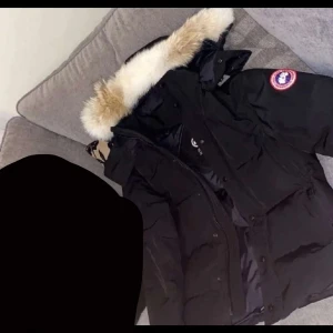 Canada goose jacka - Säljer en svart dunjacka från Canada Goose i mycket bra skick. Nypris är 20 000. Jackan har en fluffig pälsfodrad huva och är perfekt för kalla vinterdagar. Den har långa ärmar och stängs med dragkedja och knappa . Modellen är Wyndham parka heritage med äkta päls. Perfekt för både stad och natur! 
