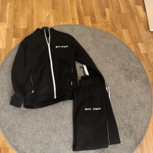 Palm Angels Tracksuit - Säljer min Palm Angels Tracksuit som är för stor för mig. Använd några få gånger. Tracksuiten ser helt ny ut och överdelen har kvar lappen från Palm Angels. Skicket på Tracksuiten är 8,5/10. Skriv om ni har fler frågor!