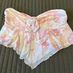 Rosa/vit tubtopp från Shein storlek:L - Säljer en snygg tubtopp från Shein i en härlig mix av rosa, vit och beige. Toppen har ett knytband framtill och ett mjukt, bekvämt material som passar perfekt för sommardagar. Aldrig använd. Säljer för 100 kronor 