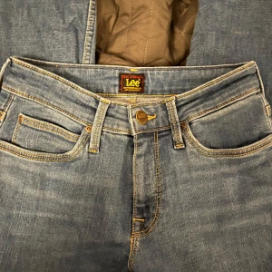 Blå jeans från Lee - Snygga blå jeans från Lee i modellen Marion Straight. Klassisk design med fem fickor och knappgylf. Perfekta för en avslappnad stil.