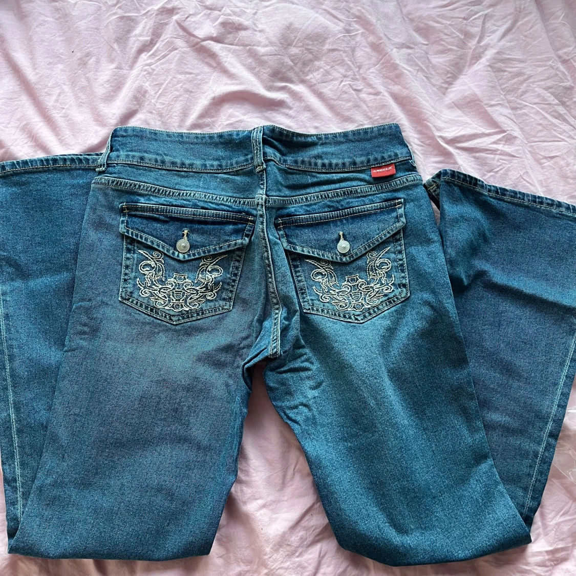 Blå jeans med broderade bakfickor