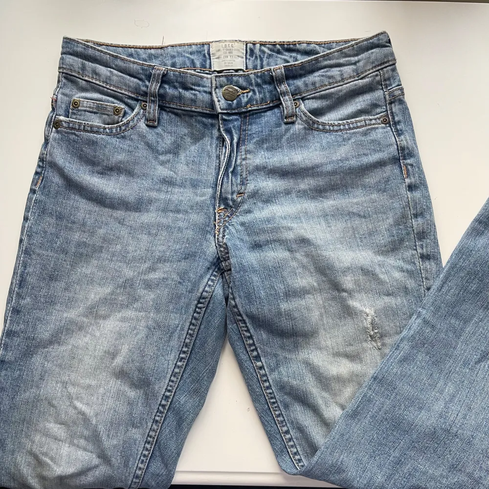 Snygga blå lågmidjade vintage jeans med raka ben. De har en ljus tvätt och har snygga slitningsdetaljer på låret. Passar bra till allt! . Farkut & Housut.