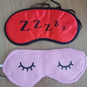 Skönhet/sovmask - 25 kr st❤️.Två sovmasker, en i rosa med ögonfransmotiv och en i röd med 'ZZZ' tryck. Båda har elastiska band för bekväm passform. 