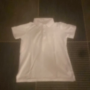 Vit kortärmad pikétröja - Snygg och klassisk vit pikétröja med korta ärmar och krage. Perfekt för en stilren look.