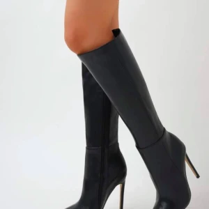 Svarta stövlar med klack - Eleganta svarta stövlar i skinn med hög klack och spetsig tå. Perfekta för en stilren look. Klacklängden är ca 10 cm skulle jag säga ej använd helt ny, kommer ej till användning köptes för 365kr