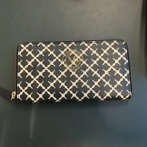 Plånbok från By Malene Birger - Jätte Snygg plånbok med Malene Birgers klassiska mönster!🤍 Plånboken har en dragkedja runtom och flera fack för kort och kontanter🤍Perfekt för att hålla ordning på dina tillhörigheter med stil. Nypris:1599kr 🤍Säljer för att jag nu har en annan som jag använder mer!