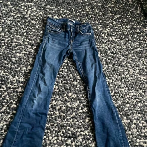 Gina trico jeans - Jeans men knappfickor. Low-mid waist. Utsvängda jeans. !Lite Slitna! !har ett hål vid fickan! Säljer dom om någon orkar sy hålet för annars måste de slängas 