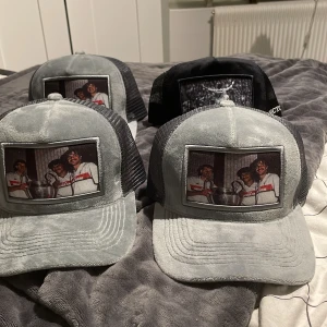 Kepsar med tryck - Säljer flera kepsar med olika tryck på framsidan. Kepsarna har en klassisk design med nät på baksidan. Finns i färgerna grå och svart. Perfekt för en avslappnad stil. Säljs i bulk för 600 kr men om man vill köpa en blir det 200 kr! Om man köper alla får man med en limiterad revenitekeps (använd)