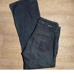 Low waist jeans me snygga fickor - Snygga mörkblå jeans med dekorativa detaljer på bakfickan och märkeslogga. Låg midja. Återsäljer dessa då ja köpte de på plick men de inte passade mig. (Lånade  bilder)🫶🏻