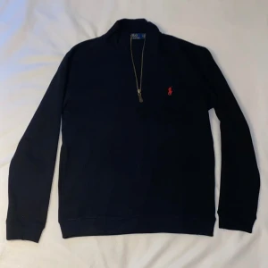 Ralph Lauren Polo Quarter Zip - Säljer en riktigt fin och klassisk quarter zip från Ralph Lauren, perfekt för både vardag och lite mer avslappnade tillfällen. Den är både stilren och bekväm, och passar bra till både jeans och chinos.  Färg: Svart Kondition: 10/10, knappt använd Storlek: M, passar mediumstorlekar  Ett utmärkt tillskott till garderoben!
